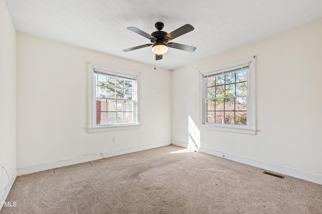 carpeted spare room featuring ceiling fan