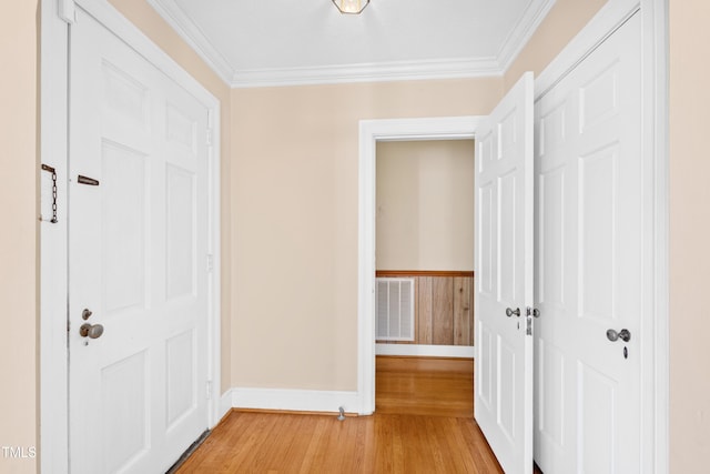 corridor with wood-type flooring and ornamental molding