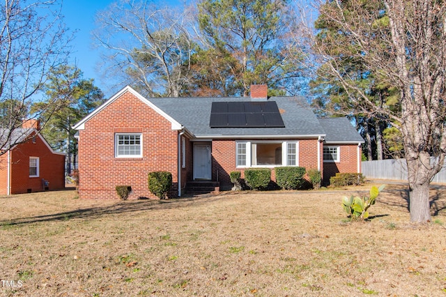 view of front of home featuring a front yard and solar panels