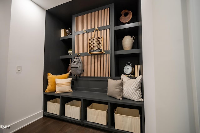 mudroom with built in features and dark wood-type flooring