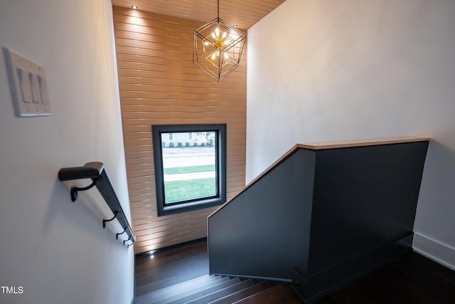 staircase featuring hardwood / wood-style flooring and an inviting chandelier