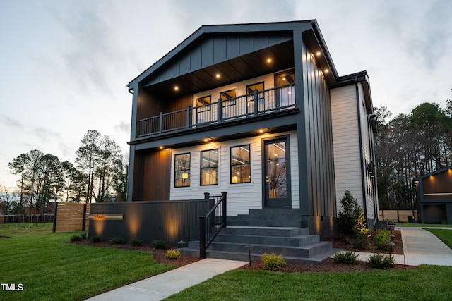 contemporary home with a yard and a balcony