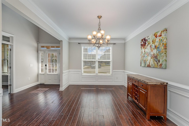 dining room featuring dark hardwood / wood-style floors, crown molding, and an inviting chandelier