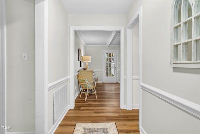 corridor featuring beam ceiling, wood-type flooring, and crown molding