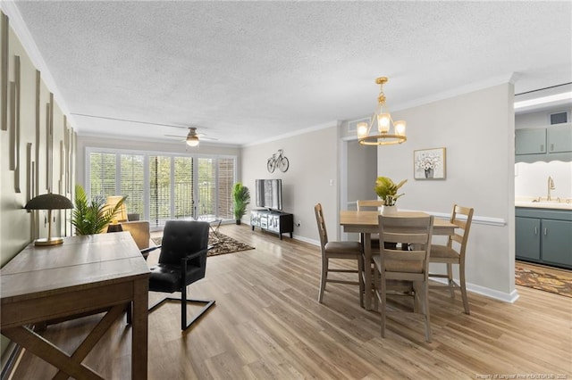 dining space featuring light hardwood / wood-style floors, ornamental molding, and sink