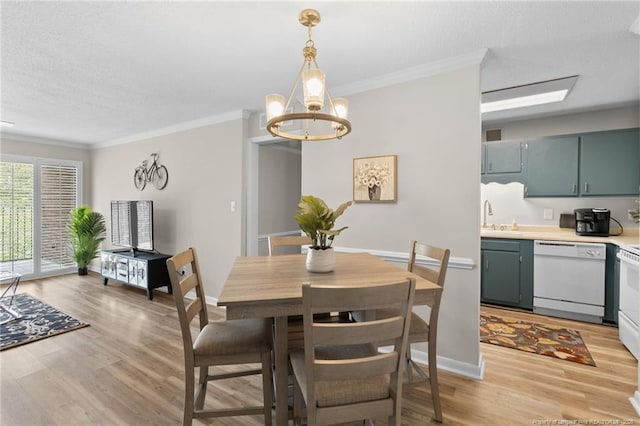 dining area with crown molding, sink, a chandelier, and light hardwood / wood-style floors