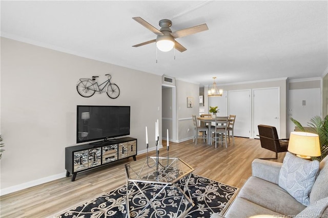 living room with ceiling fan with notable chandelier, wood-type flooring, and crown molding