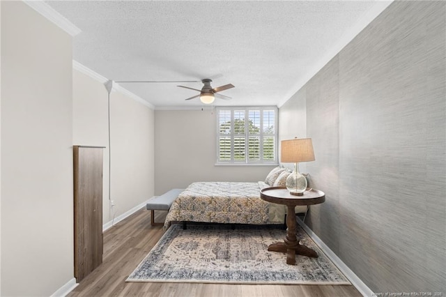 bedroom with ceiling fan, light hardwood / wood-style flooring, crown molding, and a textured ceiling