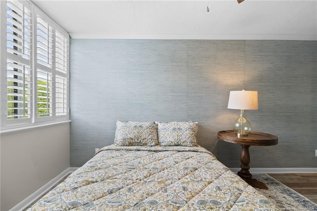 bedroom featuring crown molding and dark wood-type flooring