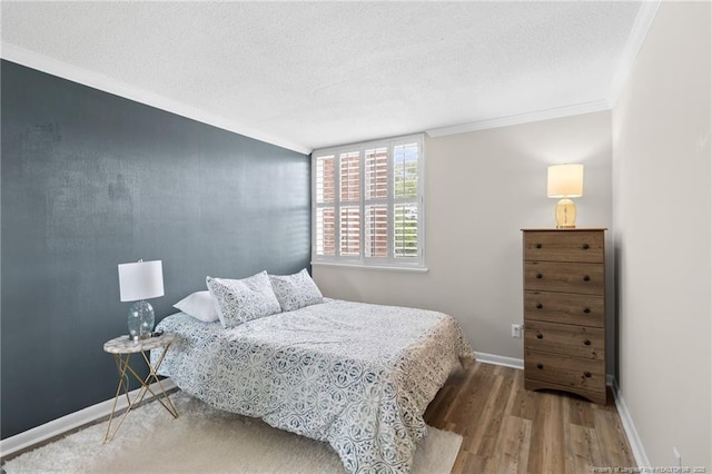 bedroom featuring crown molding, wood-type flooring, and a textured ceiling