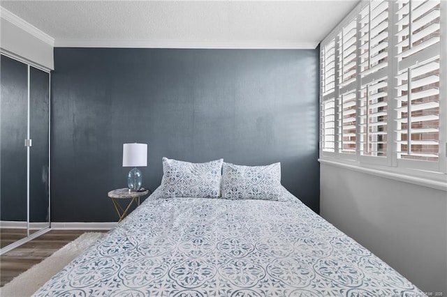 bedroom with hardwood / wood-style flooring and crown molding