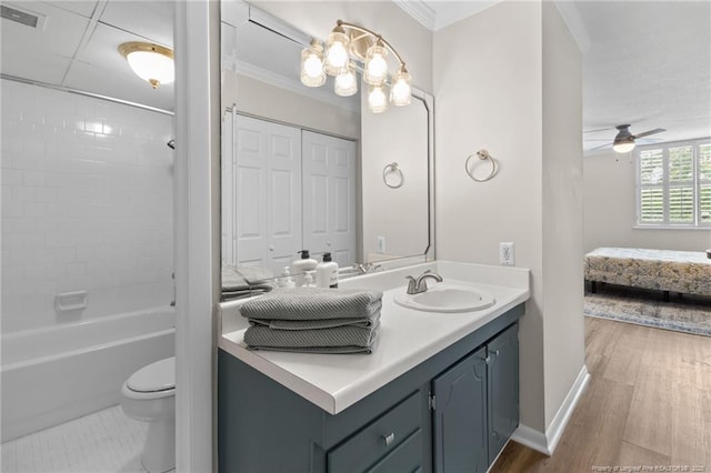 full bathroom with ornamental molding, vanity, ceiling fan, wood-type flooring, and toilet