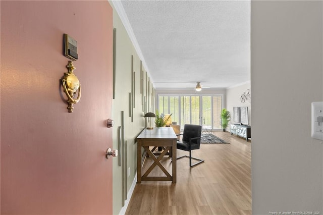 interior space with a textured ceiling, light hardwood / wood-style floors, and crown molding