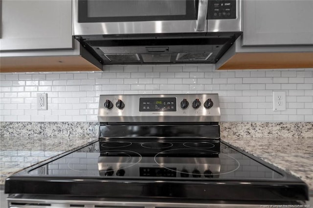 kitchen featuring tasteful backsplash, light stone counters, and stainless steel range with electric cooktop