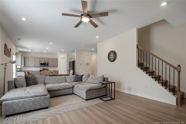 living room featuring ceiling fan and light hardwood / wood-style floors