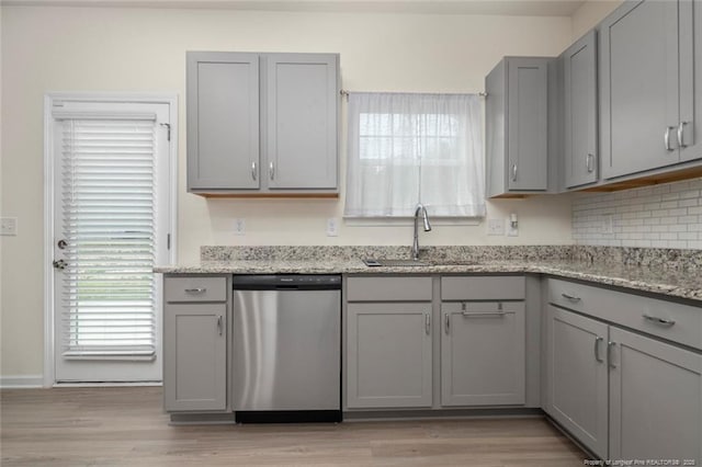 kitchen featuring gray cabinets, light stone countertops, dishwasher, and sink