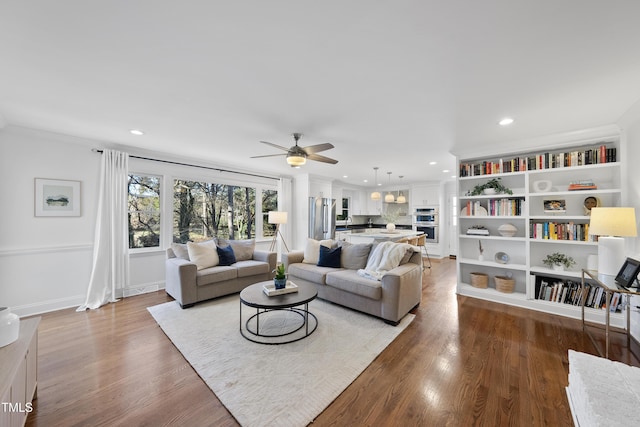 living room featuring ceiling fan, ornamental molding, and hardwood / wood-style floors