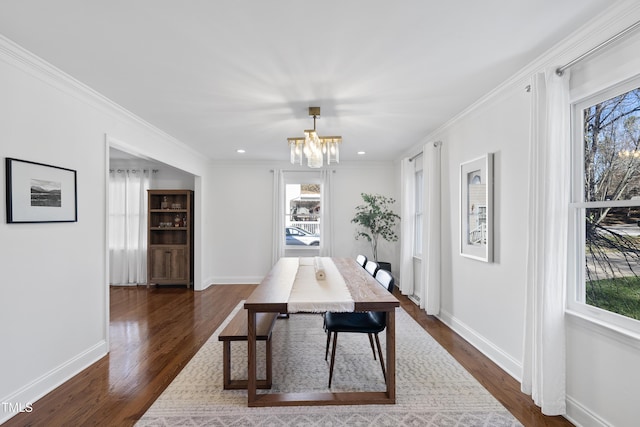 dining space featuring an inviting chandelier, crown molding, and dark hardwood / wood-style floors