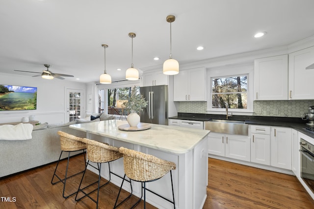 kitchen with ceiling fan, sink, stainless steel appliances, and white cabinetry