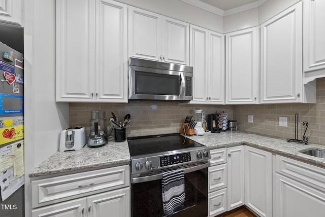 kitchen with white cabinetry, decorative backsplash, crown molding, and appliances with stainless steel finishes