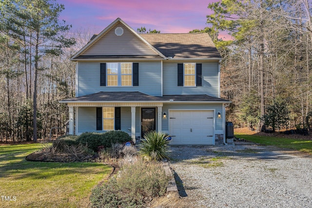 view of front property with a porch, a garage, and a yard