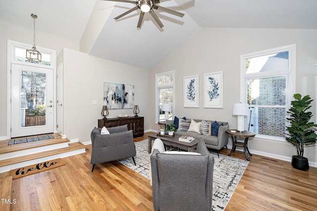 living room with ceiling fan, wood-type flooring, plenty of natural light, and high vaulted ceiling