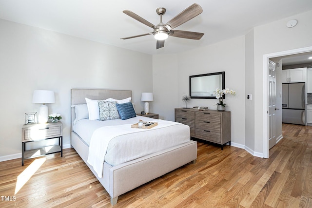 bedroom featuring ceiling fan, light wood-type flooring, and stainless steel refrigerator