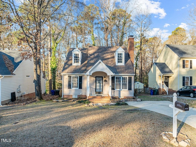 cape cod-style house with a front yard