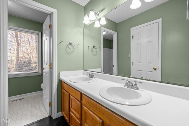 bathroom with toilet, tile patterned flooring, and vanity