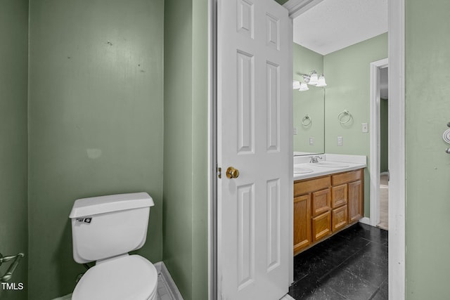 bathroom featuring a textured ceiling, toilet, and vanity