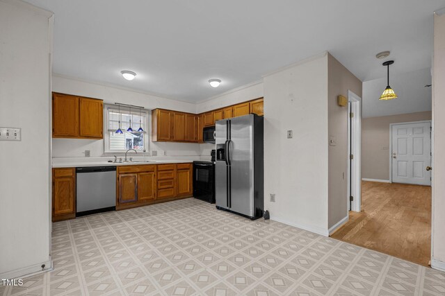 kitchen with decorative light fixtures, sink, black appliances, and light hardwood / wood-style flooring