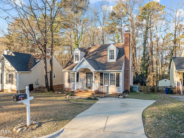 cape cod-style house with a front yard