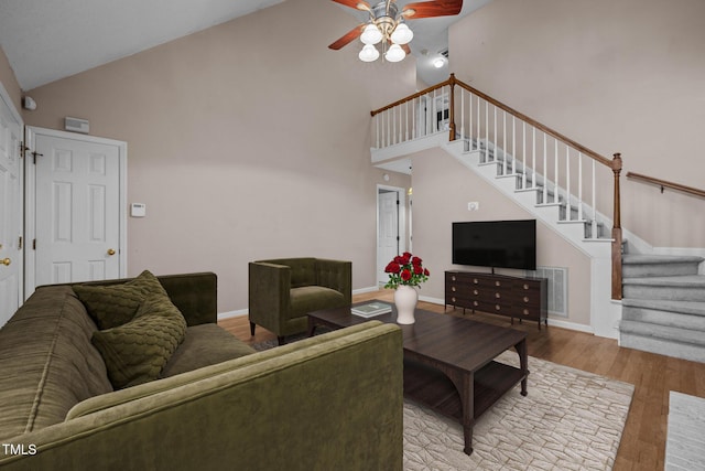 living room featuring light wood-type flooring, ceiling fan, and high vaulted ceiling