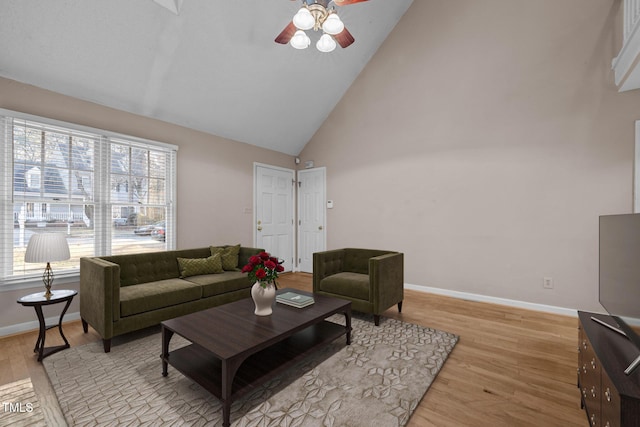 living room with light hardwood / wood-style floors, high vaulted ceiling, and ceiling fan