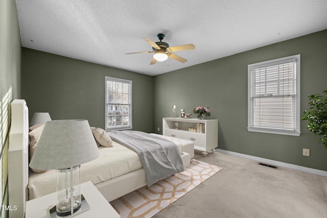 carpeted bedroom with a textured ceiling and ceiling fan