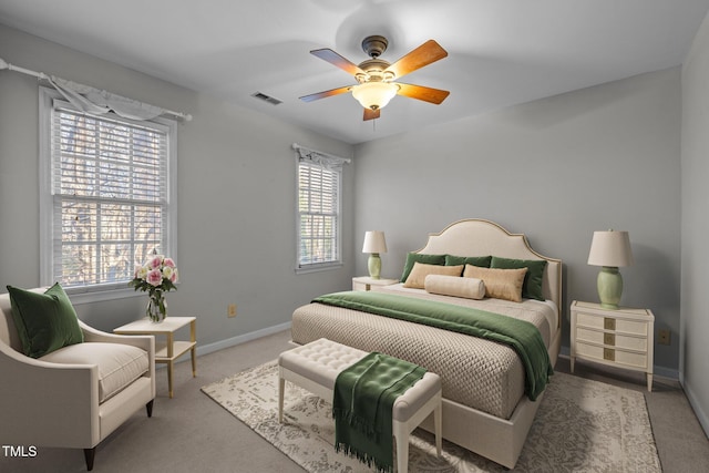 carpeted bedroom with ceiling fan and multiple windows