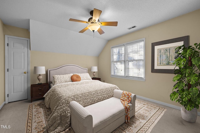 carpeted bedroom featuring vaulted ceiling, ceiling fan, and a textured ceiling