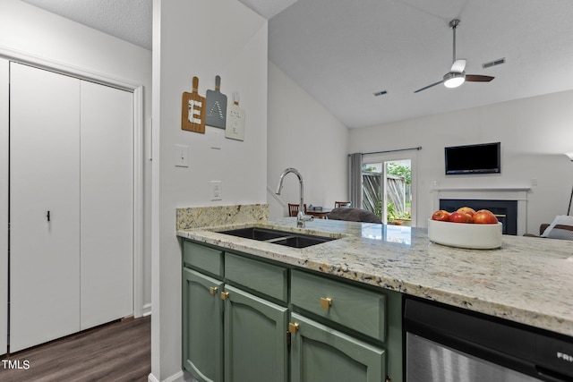 kitchen with light stone counters, ceiling fan, dark wood-type flooring, sink, and green cabinets