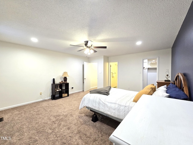 carpeted bedroom featuring a textured ceiling, ensuite bathroom, and ceiling fan