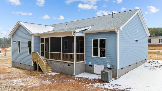 snow covered property featuring a sunroom and central AC unit