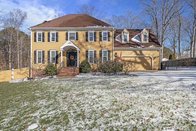 colonial home featuring a yard and a garage