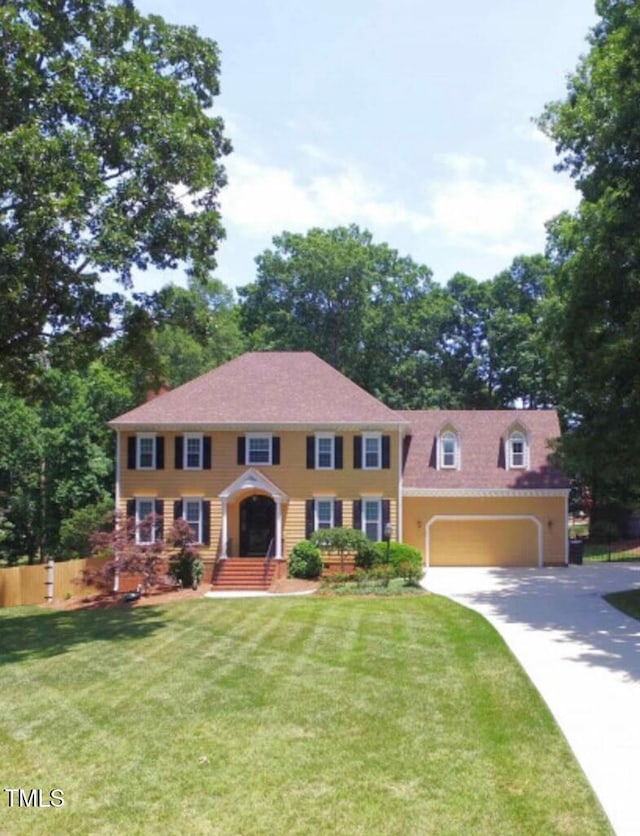 colonial-style house with a garage and a front yard