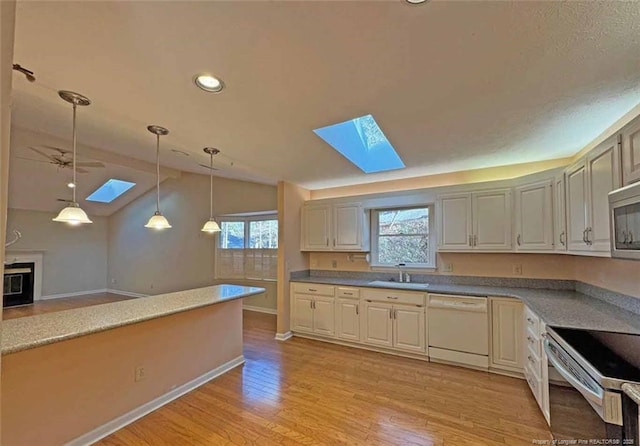 kitchen with a wealth of natural light, white dishwasher, ceiling fan, sink, and hanging light fixtures