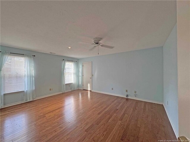 spare room featuring wood-type flooring, a textured ceiling, and ceiling fan