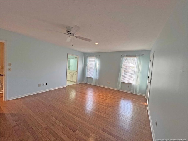 unfurnished room with ceiling fan, a textured ceiling, and light hardwood / wood-style flooring