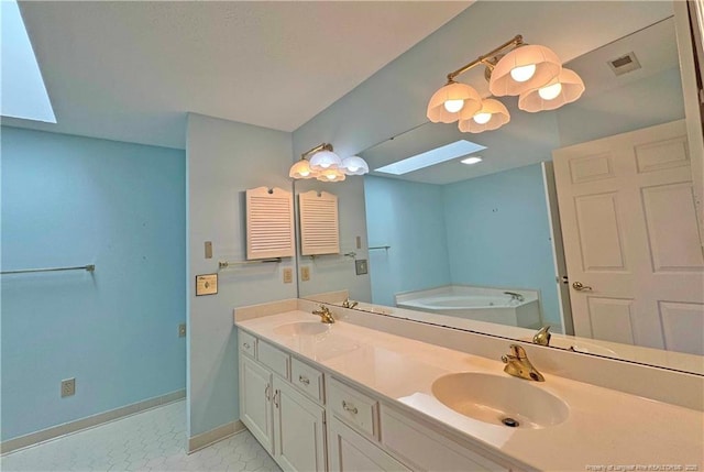 bathroom with a washtub, vanity, a skylight, and tile patterned flooring