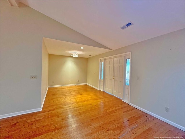 entryway with vaulted ceiling and light hardwood / wood-style flooring