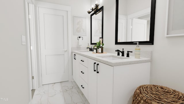 full bath featuring double vanity, marble finish floor, and a sink