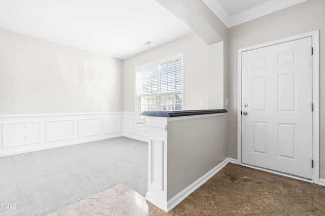 carpeted entryway featuring ornamental molding