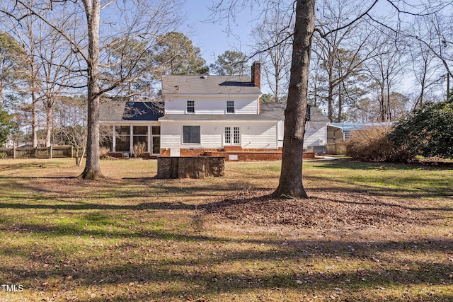 back of house with a yard and a sunroom